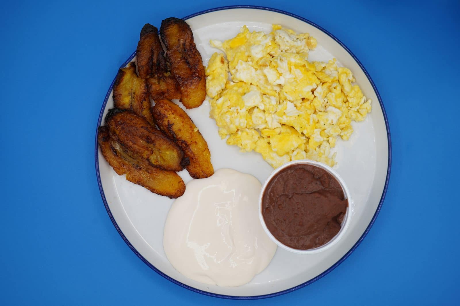 Desayuno típico salvadoreño con frijoles, huevos y plátano en Houston TX