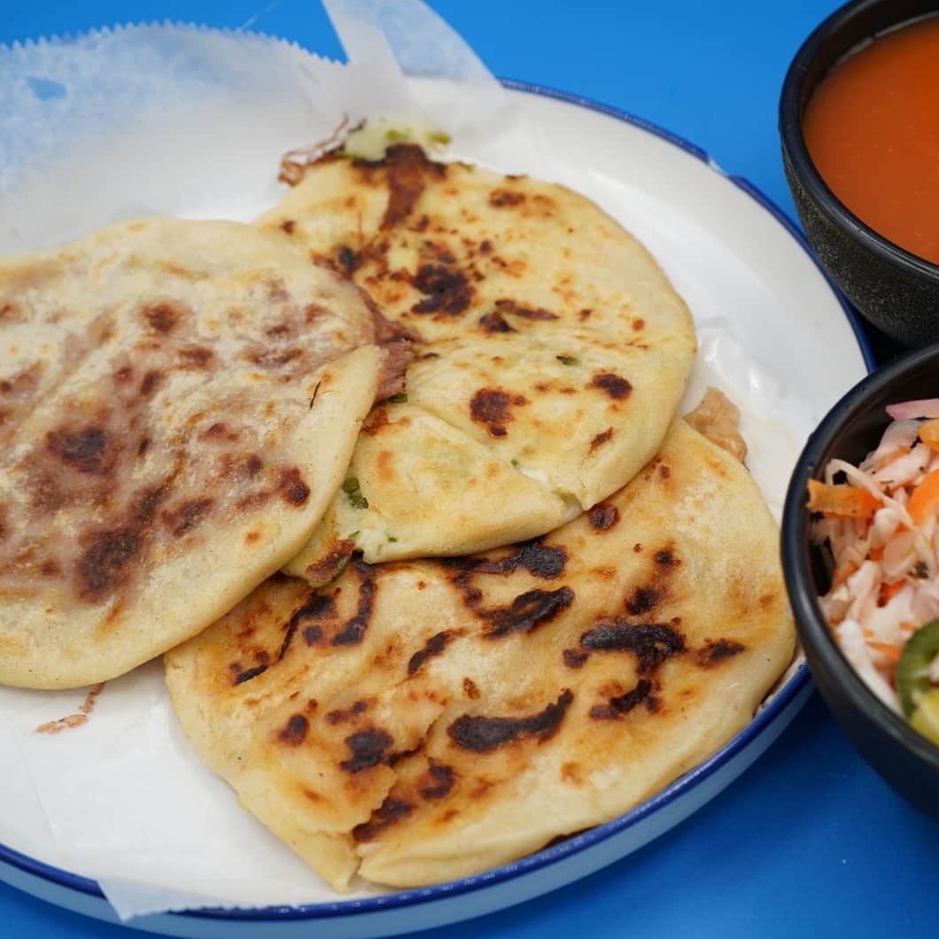 Plato de pupusas salvadoreñas con curtido y salsa en Variedades La Oriental, Houston