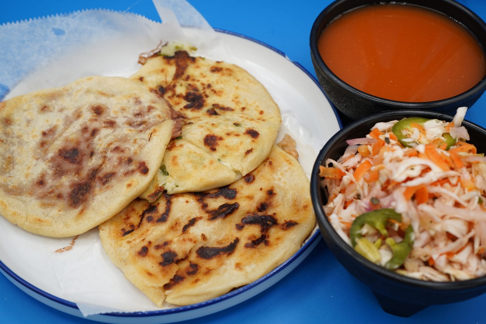 Pupusas revueltas salvadoreñas frescas del comal con curtido y salsa en Houston TX